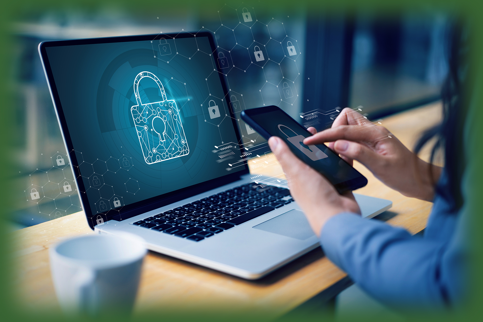 woman holding cell phone looking a digital drawing on a laptop